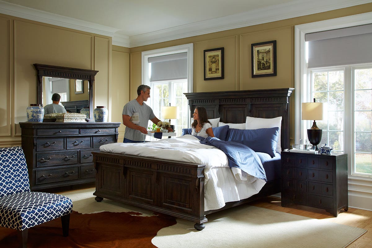 Couple in Bedroom with Partially Open Blackout Roller Shades