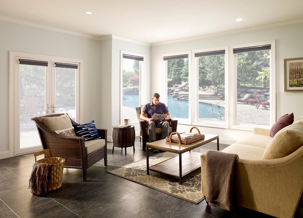 Man in Sunroom with Open Honeycomb Shades in Color Storm